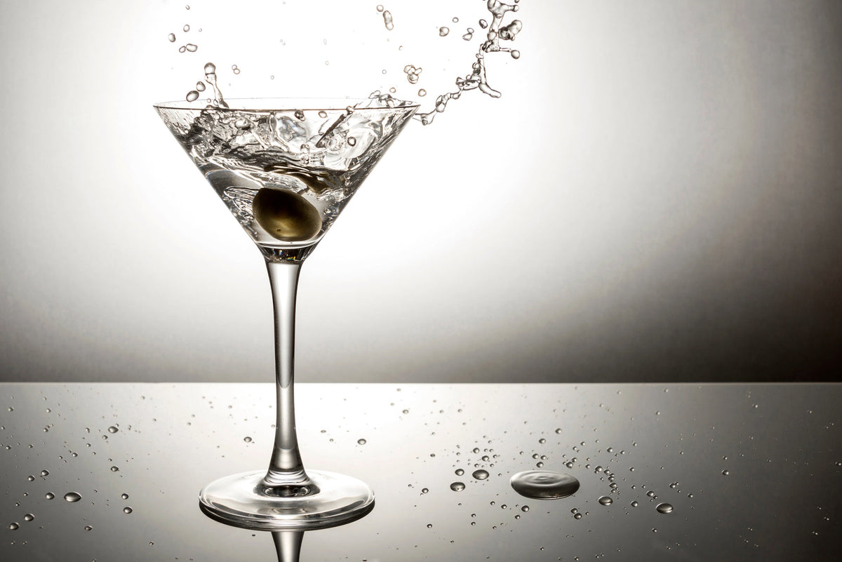 Olive splashing on martini